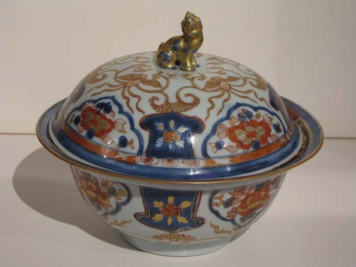 Rare Chinese Imari Covered Tureen with an Armorial Crest Facing up from the Well.  The Cover Mounted with a Buddhist Lion Knop Surrounded by Four Linked Gilt Phoenix. The Cover and the Bowl Both Shown with Tree Peony-Filled Cartouches