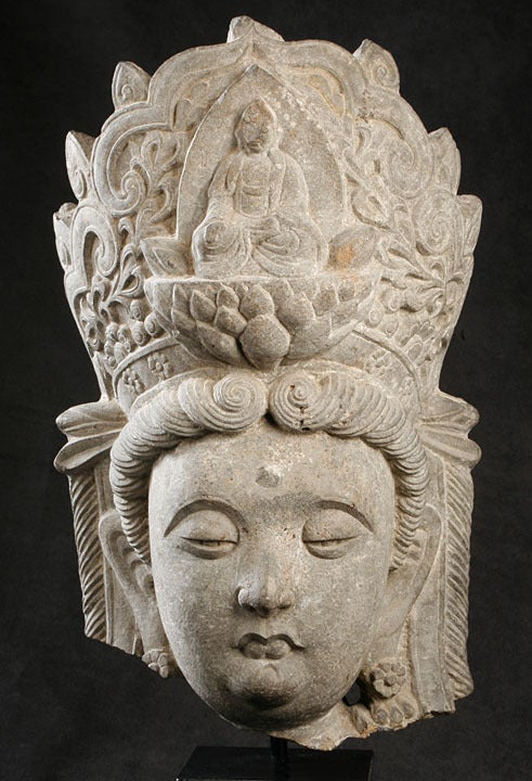 Beautiful Representation of the Bodhisattva Guanyin.
The Round, Sloe-Eyed, Sensual-Lipped Face, Ringed by Scrolling Curls, Surmounted by an Elaborate Head-Dress Featuring the Buddha Seated on a Lotus Throne.