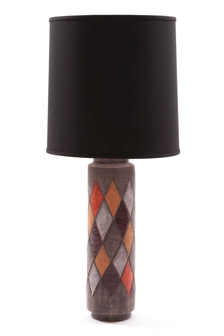 Pair of whimsical argyle lamps by Raymor, circa late 1950s. These examples have inset circular bases and have diamond forms in hues of oranges and browns. Price does not include shades.
