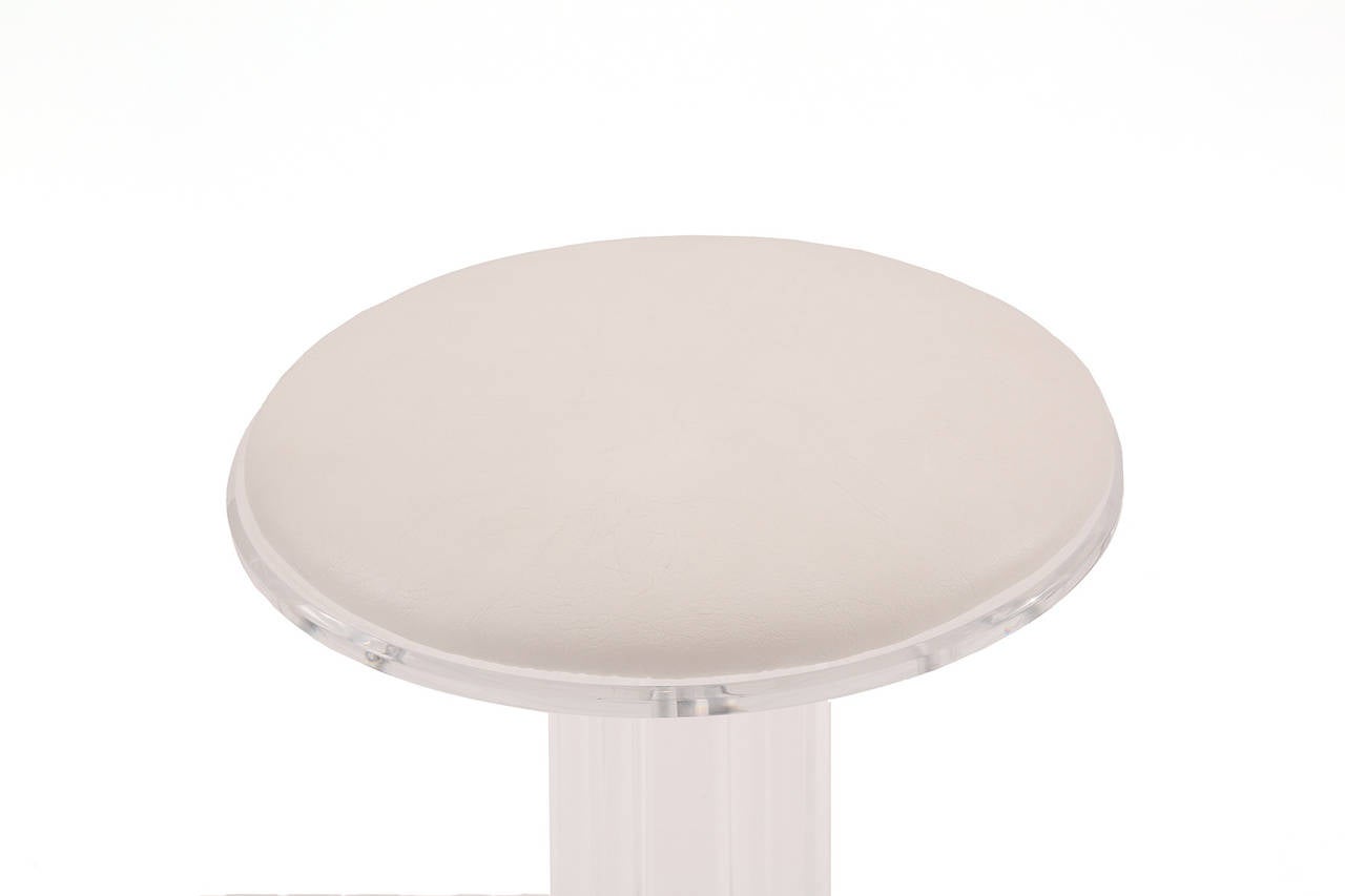 Pair of Lucite chrome and upholstered counter stools, circa mid-1970s. These chic examples have stout splayed Lucite legs chrome ring stretchers and are upholstered in white vinyl. Price listed is for the pair. Width: 17.5