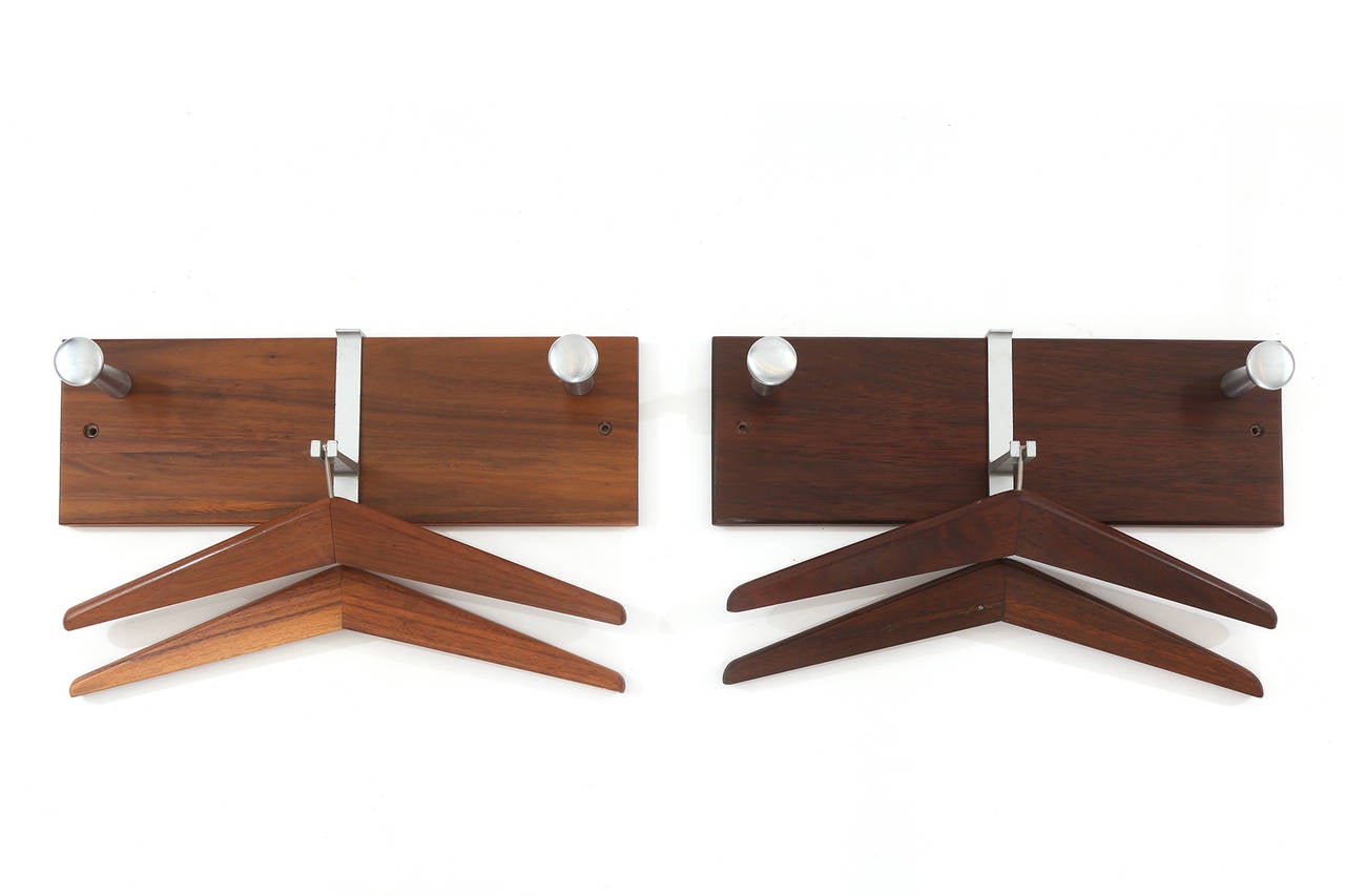 Pair of 1950s wall-mounted walnut and steel coat hangers. These functional and chic examples have two walnut and steel hangers per unit and George Nelson thin edge style pulls for additional hanging. Price listed is for a single piece.  There are 3