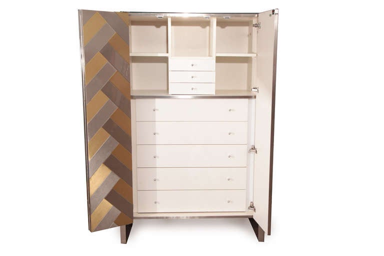 Stunning Chevron front chest by Ello, circa early 1970s. This all original example has inset steel and brass patterned doors and glass top. The sides are satin finished steel and the interior has white lacquered drawers and adjustable shelves.