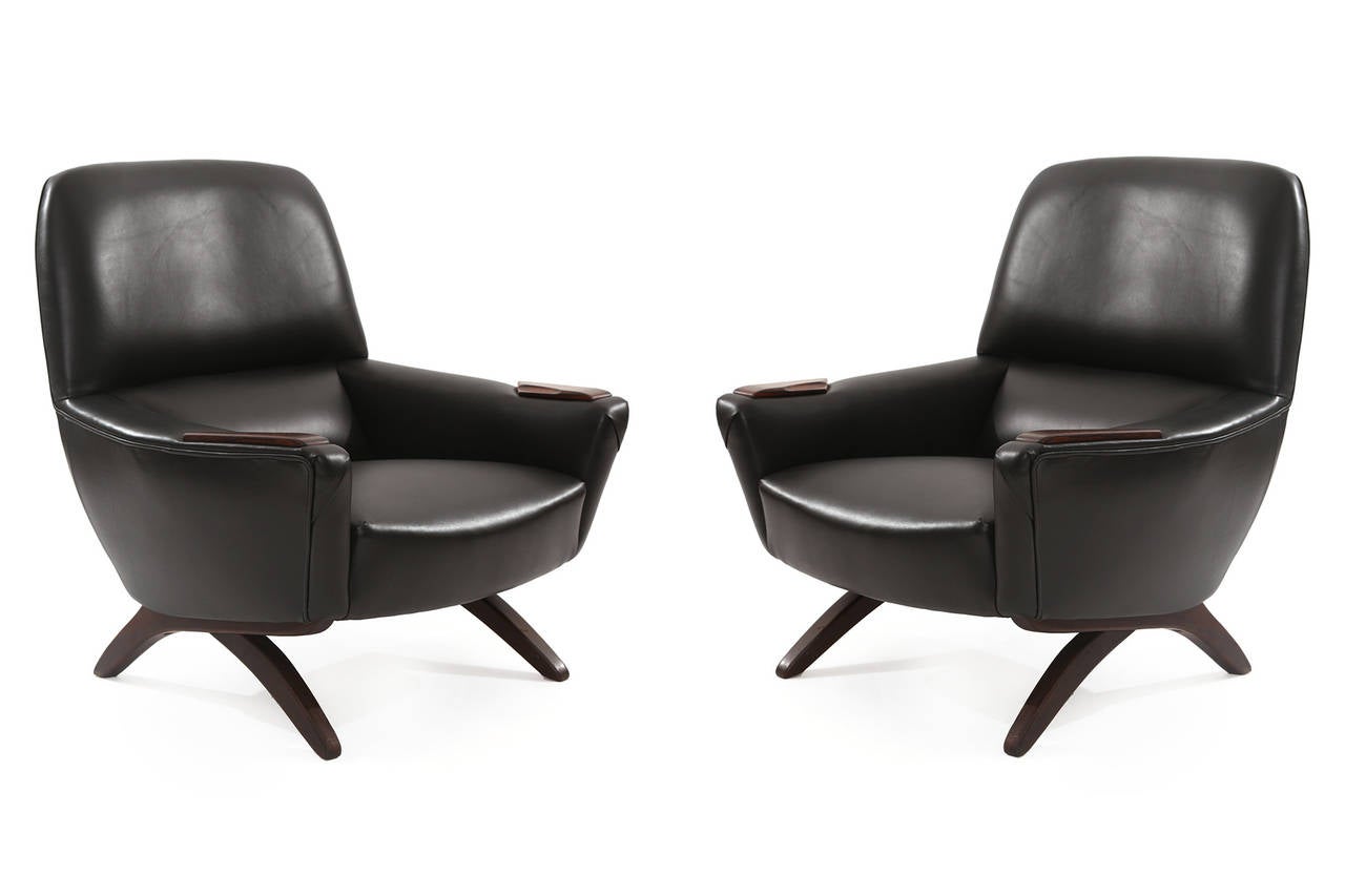 Pair of handsome leather and rosewood lounge chairs by Leif Hansen, circa early 1960s. These examples have subtly curved solid rosewood legs and inset sculpted rosewood arms. They have been newly upholstered in a supple black leather. Price listed