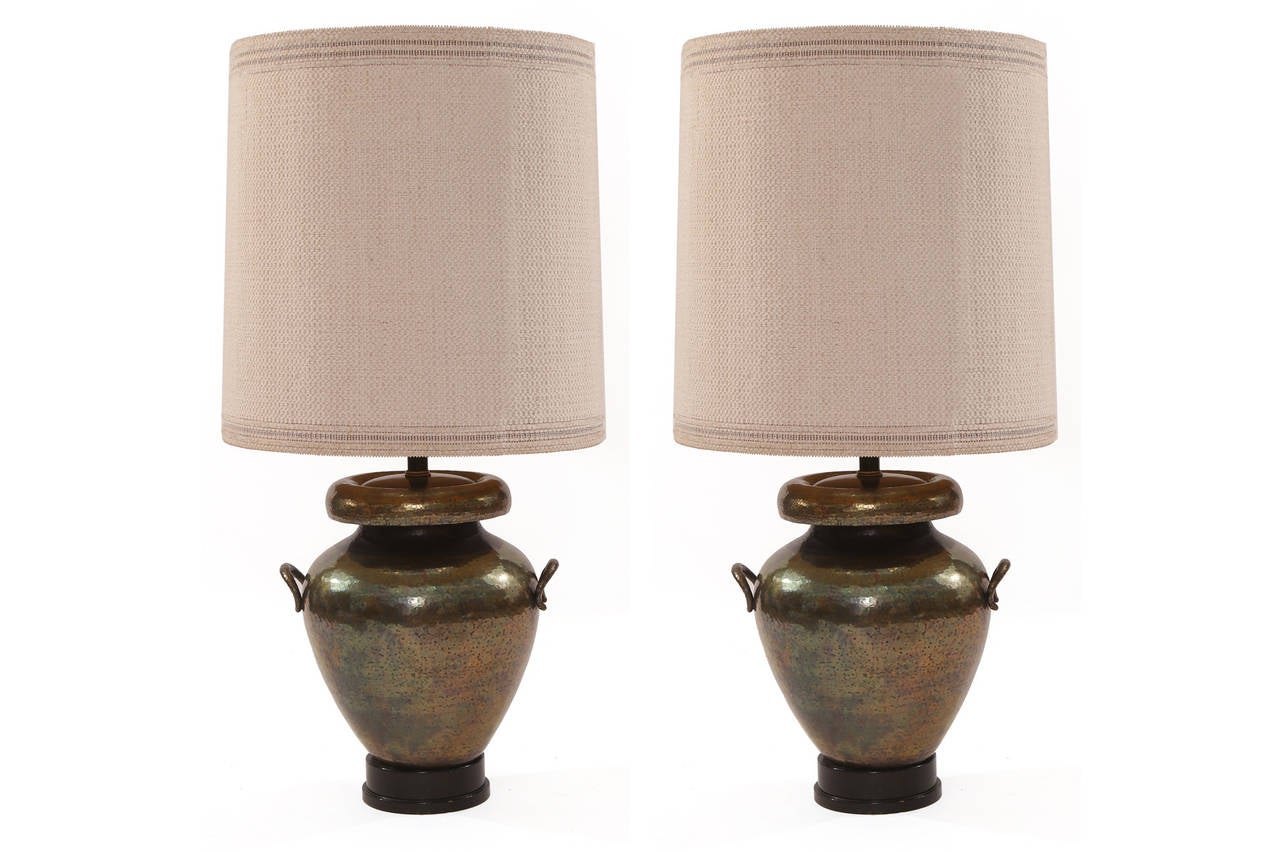 Massive pair of bronze and ebonized walnut table lamps, circa early 1950s. These examples have fabulous sculptural forms and their original woven shades. Price listed is for the pair.