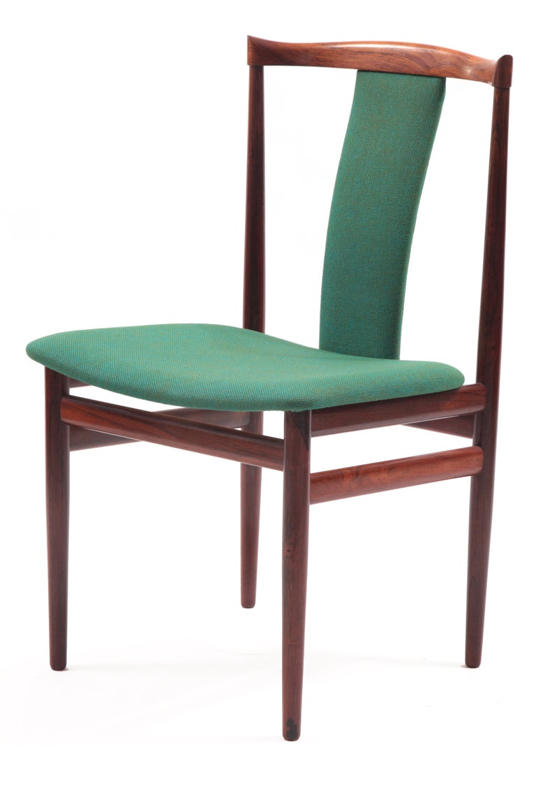 Six sculptural rosewood dining chairs from Denmark, circa mid-1960s. These all original examples have incredibly grained rosewood frames subtly curved backs and are upholstered in their original emerald green upholstery. Price listed is per chair.