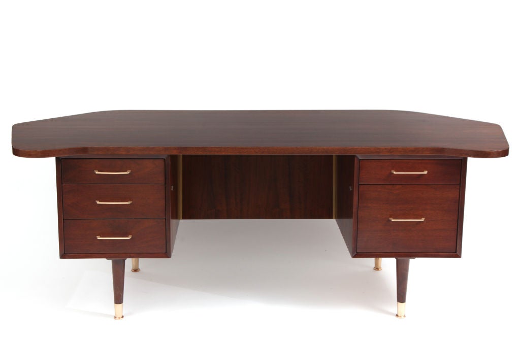 Free form walnut and brass desk circa early 1970's. This example has a wonderfully grained biomorphic walnut top, finished back and five drawers with satin finished brass pulls. Excellent restored condition.