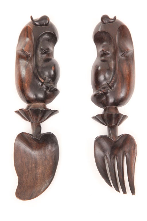Set of six exotic wood figural serving utensils circa early 1970's. These examples have free form beautifully carved faces and organically shaped spoon and fork forms. the measurements listed are for the larger set. The smaller set measures 9