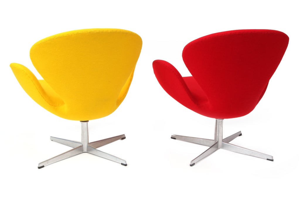 Pair of Arne Jacobsen for Fritz Hansen swan chairs circa early 1960's. These examples retain their original vibrant yellow and red upholstery and have recently been refoamed. Price is for the pair.  We also have another pair of swan chairs that have