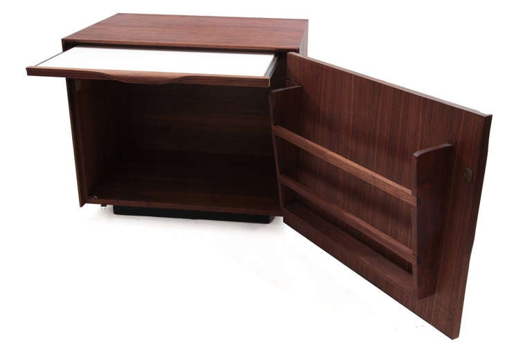 Lovely pair of John Kapel for Glenn of California nightstands or end tables, circa mid-1960s. These all original examples have walnut cases and formed walnut pulls. The interiors have built in magazine holders and pull-out trays. Price listed is for