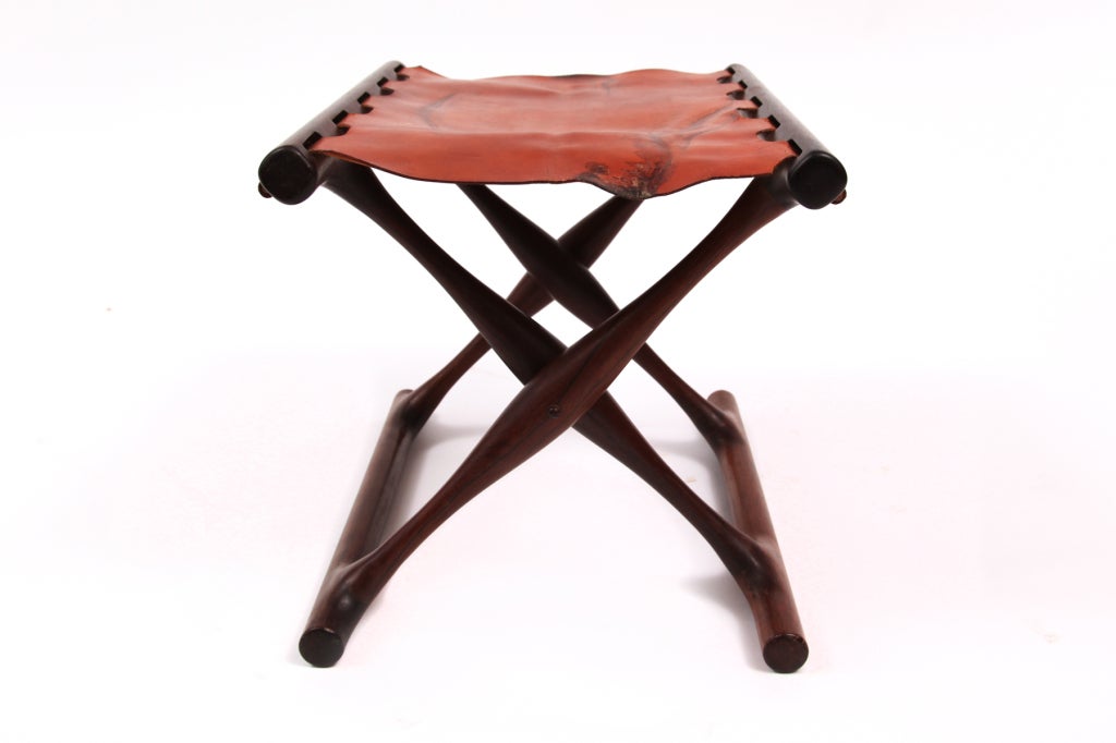 Rare Poul Hundevad rosewood and leather folding stool circa late 1950's. This example is in solid rosewood and has it's original darker caramel leather sling. The leather does have some wear and we could easily replace it in the color of your