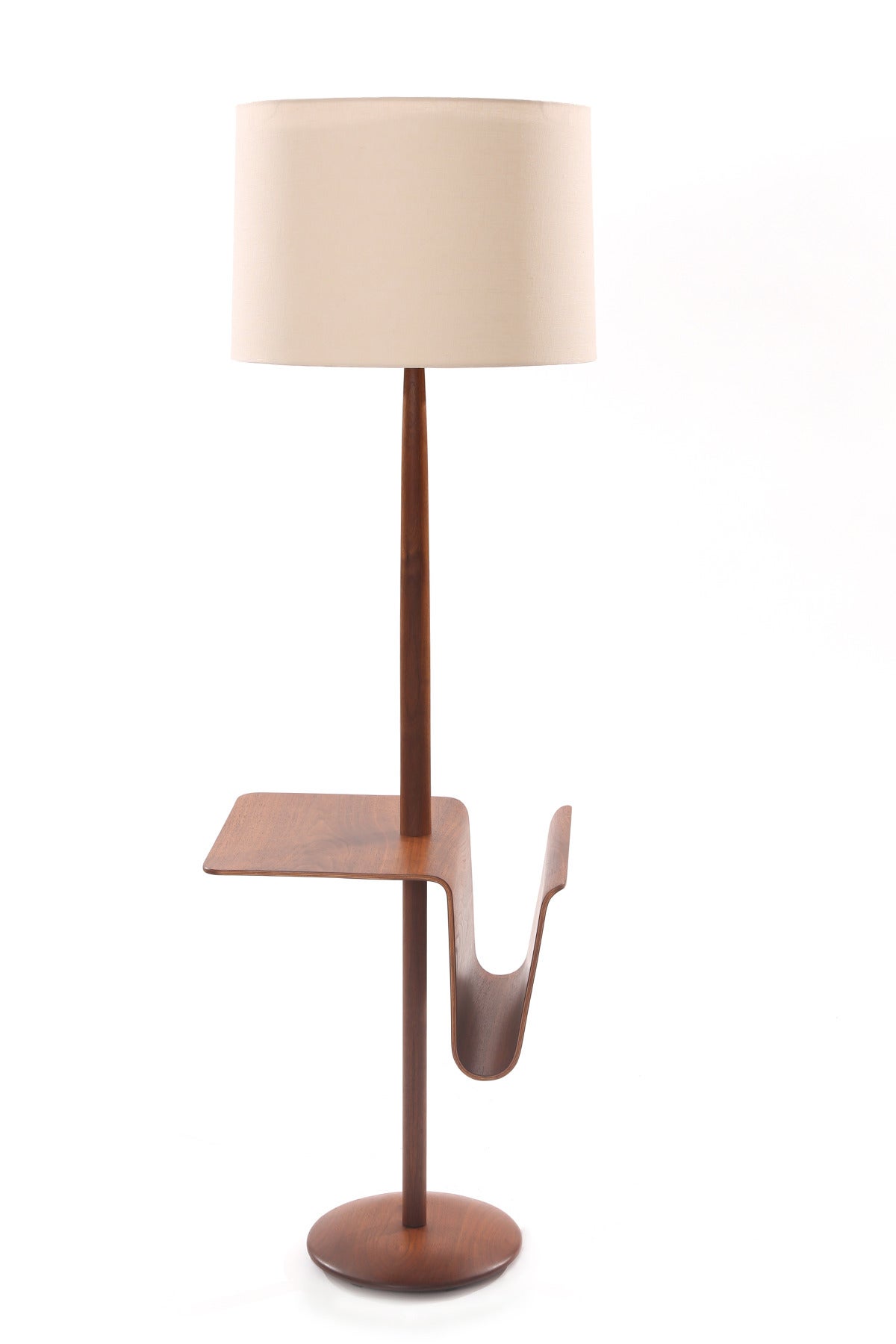 Sculptural oiled walnut floor lamp with magazine holder, circa mid-1960s. This lovely example has a solid walnut pole with a bentwood beautifully grained magazine holder. Price listed does not include the shade.
