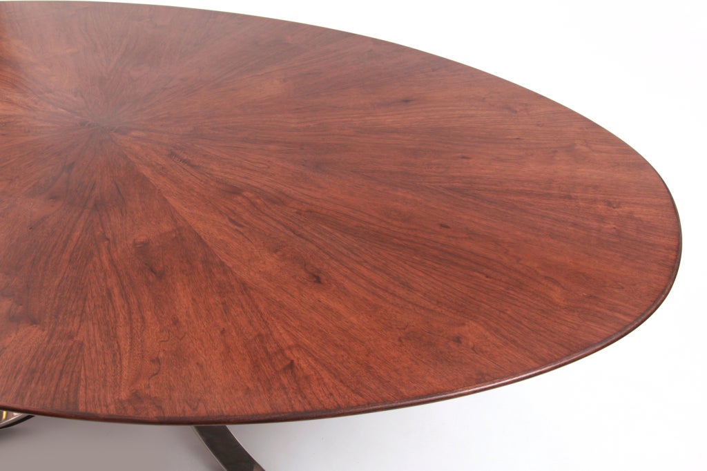 Osvaldo Borsani walnut and sculpted steel oval dining table circa late 1960's. This example has a wonderful book matched walnut top with a knife edged bevel and sits atop a bright chrome curved steel base. Top has recently been refinished. This