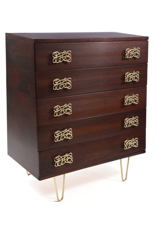 Striking walnut and brass high boy chest of drawers circa late 1950's. This 5 drawer example has sculptural scraffito brass drawer pulls and hand rubbed brass hairpin legs. The walnut case has tapered sides and has been impeccably refinished. Please