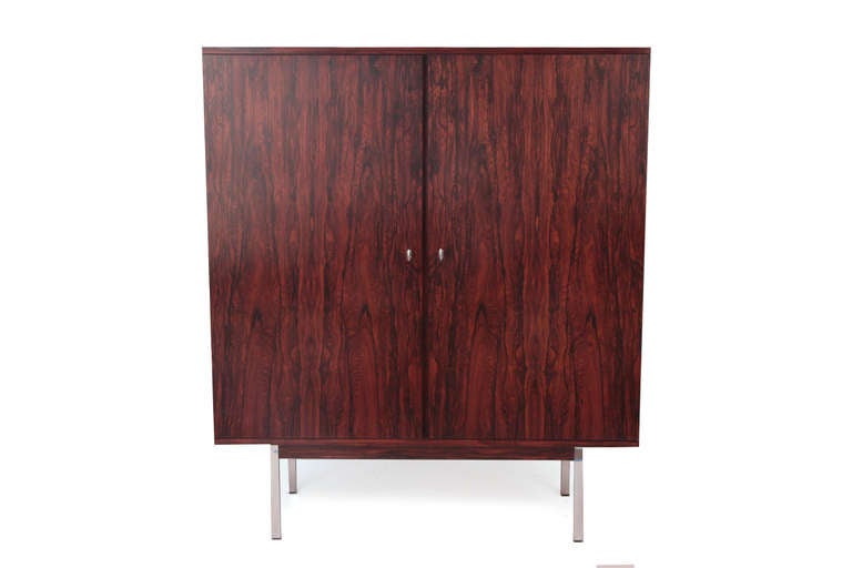 Stunning rosewood and steel high boy from Denmark, circa mid-1960s. This remarkable example has an exquisitely grained rosewood case with two large doors that open to reveal a beautiful maple interior with three six adjustable shelves. This has