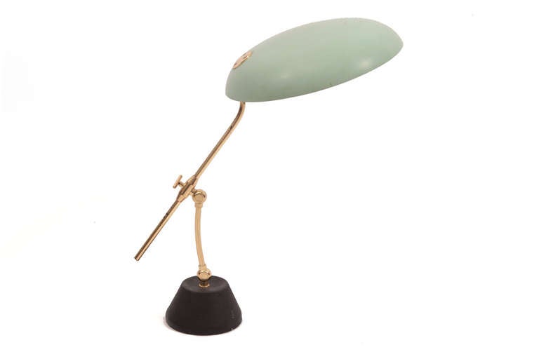 Articulating and adjustable table lamp from Italy circa mid-1960s. This example has a weighted iron base, sea foam green metal shade and adjustable brass stem.