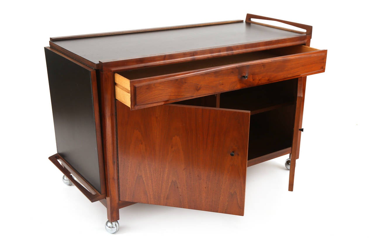 Glenn of California expandable bar cart, circa late 1960s. This all original example was designed by John Kapel and has more than ample interior storage and adjustable sliding top with inset black Formica. Please see our other listings for the