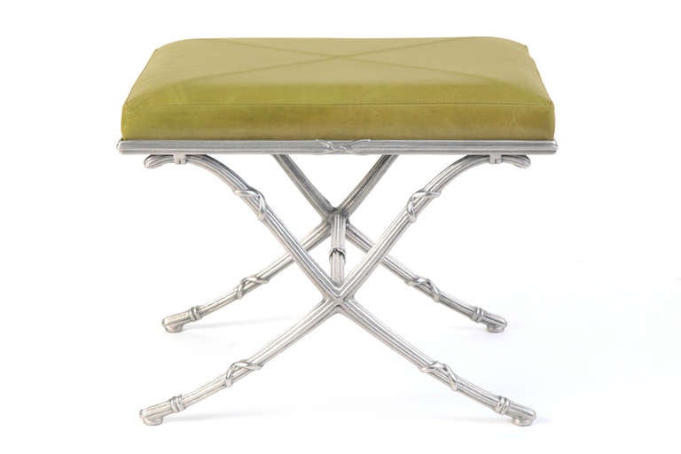 Pair of polished aluminum and leather ottomans circa early 1960's. These examples have lovely solid aluminum x bases that have recently been polished. The leather tops have been newly upholstered in a granny smith green leather with double stitched