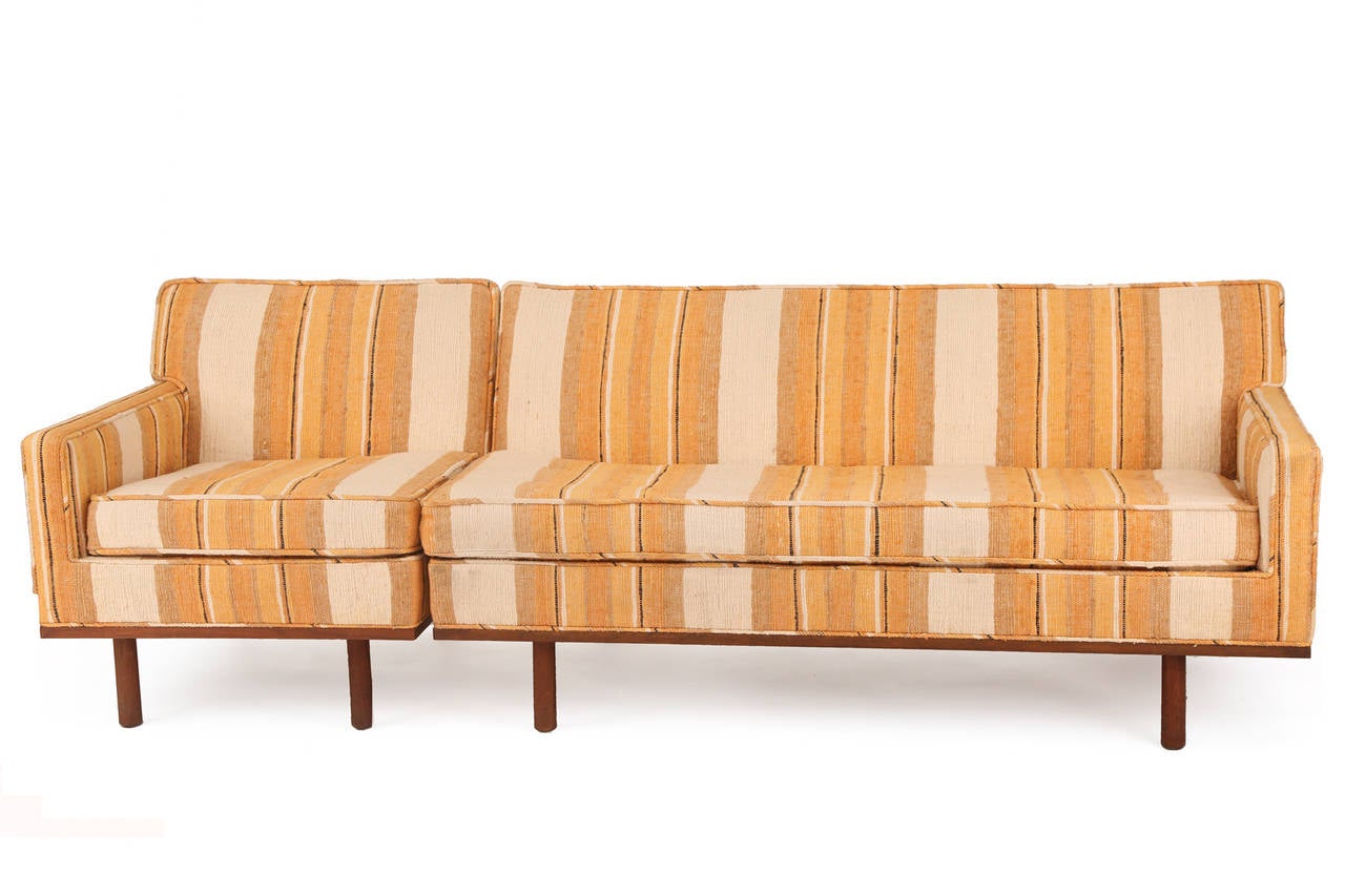 All original Metropolitan sofas, circa early 1960s. These examples have their original striped cotton upholstery with hues of oranges off white's taupe and black. The legs and stretchers are solid walnut. The set is versatile in that it can be