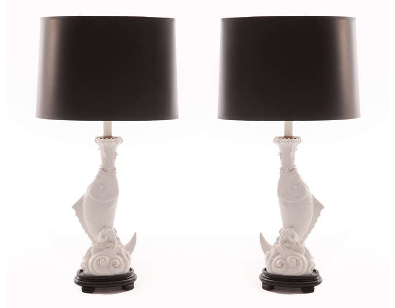 Pair of highly detailed porcelain fish lamps circa early 1950's. These decorative examples have a white glaze and are adorned with new black dome shades. Price listed is for the pair.