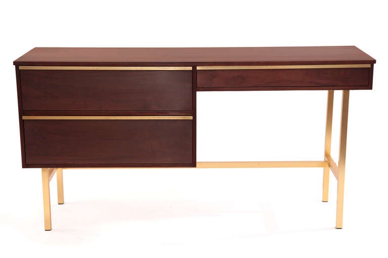 Custom solid walnut and brass desk circa late 1950's. This lovely example has a solid walnut top sides and drawer fronts with satin finished brass legs and drawer pulls. It has recently been impeccably refinished.