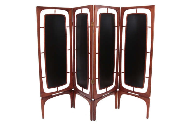 Sculptural four-panel teak folding screen from Denmark, circa late 1950s. This freestanding adjustable example has tapered solid teak frames with inset book matched teak fronts and backs. It is finished on both sides.