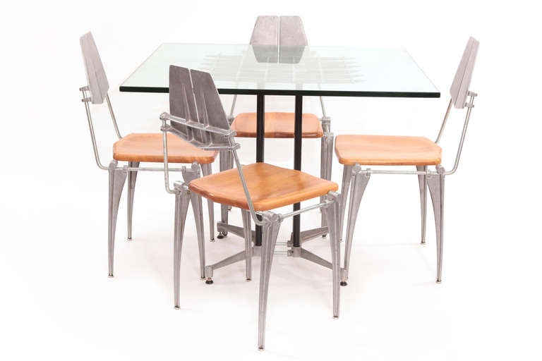 All original table and four chairs designed by Robert Josten, circa early 1970s. The table of this set has an enameled grid top and cast aluminum base. The chairs have solid maple seats and Josten's unmistakable aluminum forms. Price listed is for