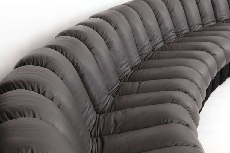 Early 20 section never ending sofa by Ueli Berger for Stendig circa early 1970's. This example has its original black felted wool and has been newly upholstered in a lovely and supple charcoal gray leather. This sofa's versatility is such that it