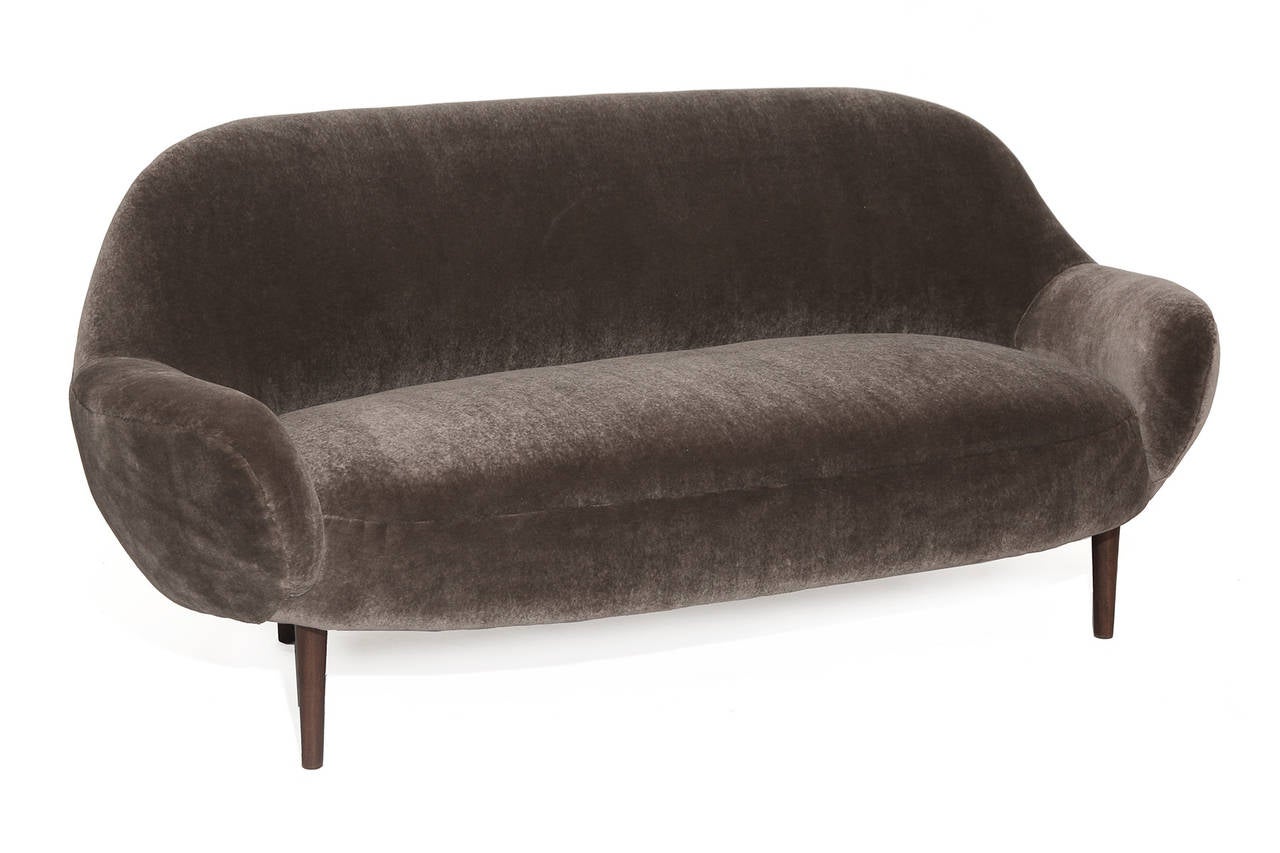 Sculptural mohair and oak sofa or loveseat from Denmark, circa mid-1950s. This example has wonderfully curved arms and has been newly upholstered in thick and supple mohair.

Arm height: 19.75