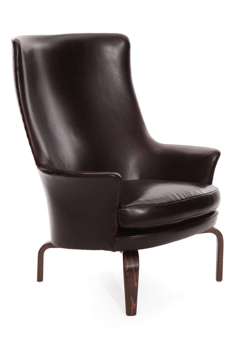 Fabulous high back leather lounge chair by Arne Norell, circa early 1960s. This example has beautifully grained bentwood legs and has been hand-stitched around the entire exterior and newly upholstered in a phenomenal chocolate brown leather.
