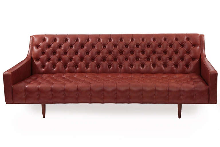 Exquisite diamond tufted cognac leather sofa, circa late 1950s. This example has been newly upholstered in a supple and chic cognac leather and sits atop four solid walnut legs.
