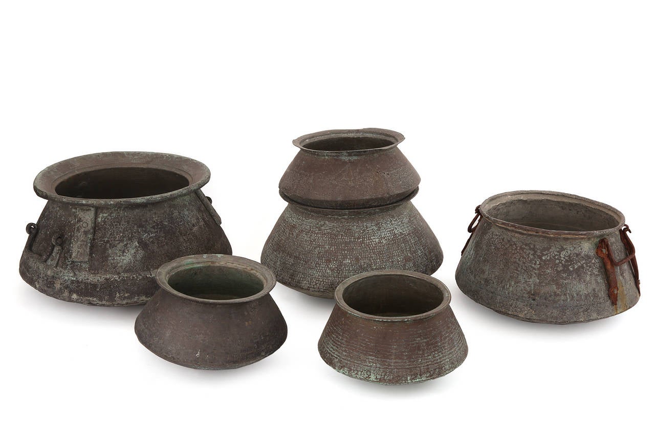 19th century massive copper pots from Saudi Arabia. These stunning examples are all hand-forged and each have incredible patina. They are fabulous as sculptures or planters and can be stacked. There are a pair of the examples with footed bases and