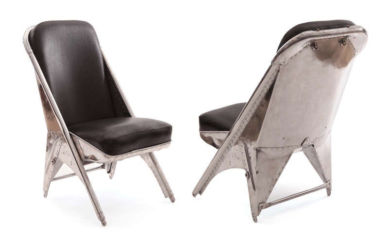 Rare riveted aluminum and leather chairs from a 1940s Cessna airplane. These phenomenal examples have recently been mirror polished have new tapered black leather seats and backs and have hooks on the reverse sides of the chairs for your very own