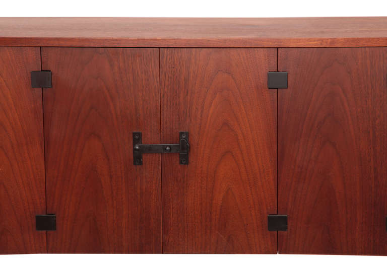 Kipp Stewart for Directional wall mounted credenza, circa late 1960s. This example combines finely grained with ebonized accents. It has recently been sanded and oiled and has a French pleat for easy wall mounting.