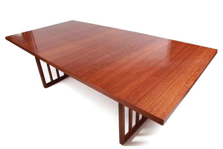 T.H. Robsjohn-Gibbings for Widdicomb dining table, circa early 1950s. This example has a beautifully grained walnut top with two leaves and elegant doweled solid walnut base. Each leaf is 16