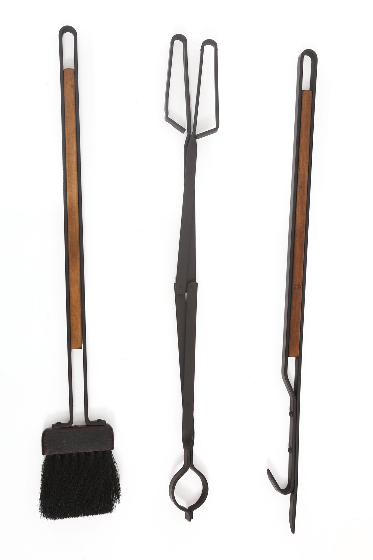 Sculptural iron and wood fireplace tools, circa mid-1960s. These examples have solid iron frames with inset wood detailing.