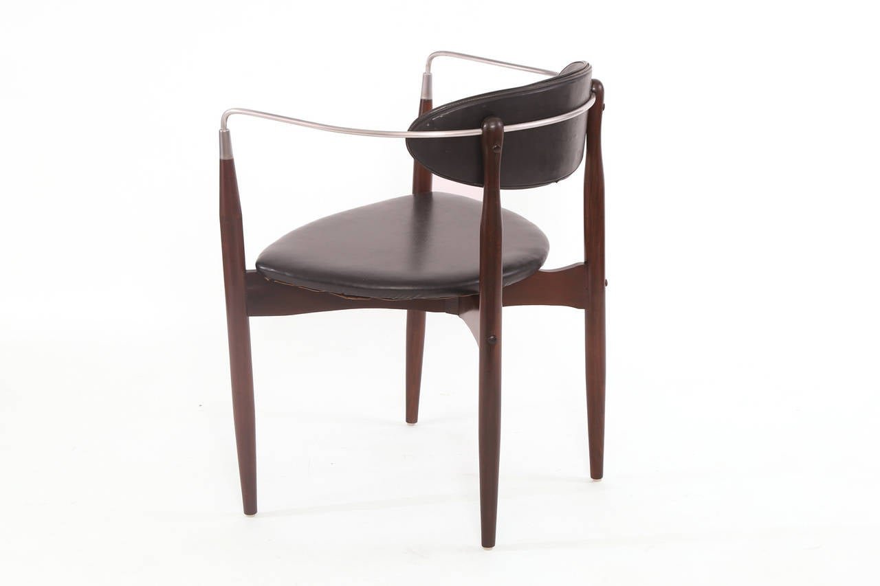 Viscount chair by Dan Johnson, circa late 1950s. This example has a hand rubbed nickel arm and back and newly finished walnut frame. It is upholstered in its original black vinyl upholstery.