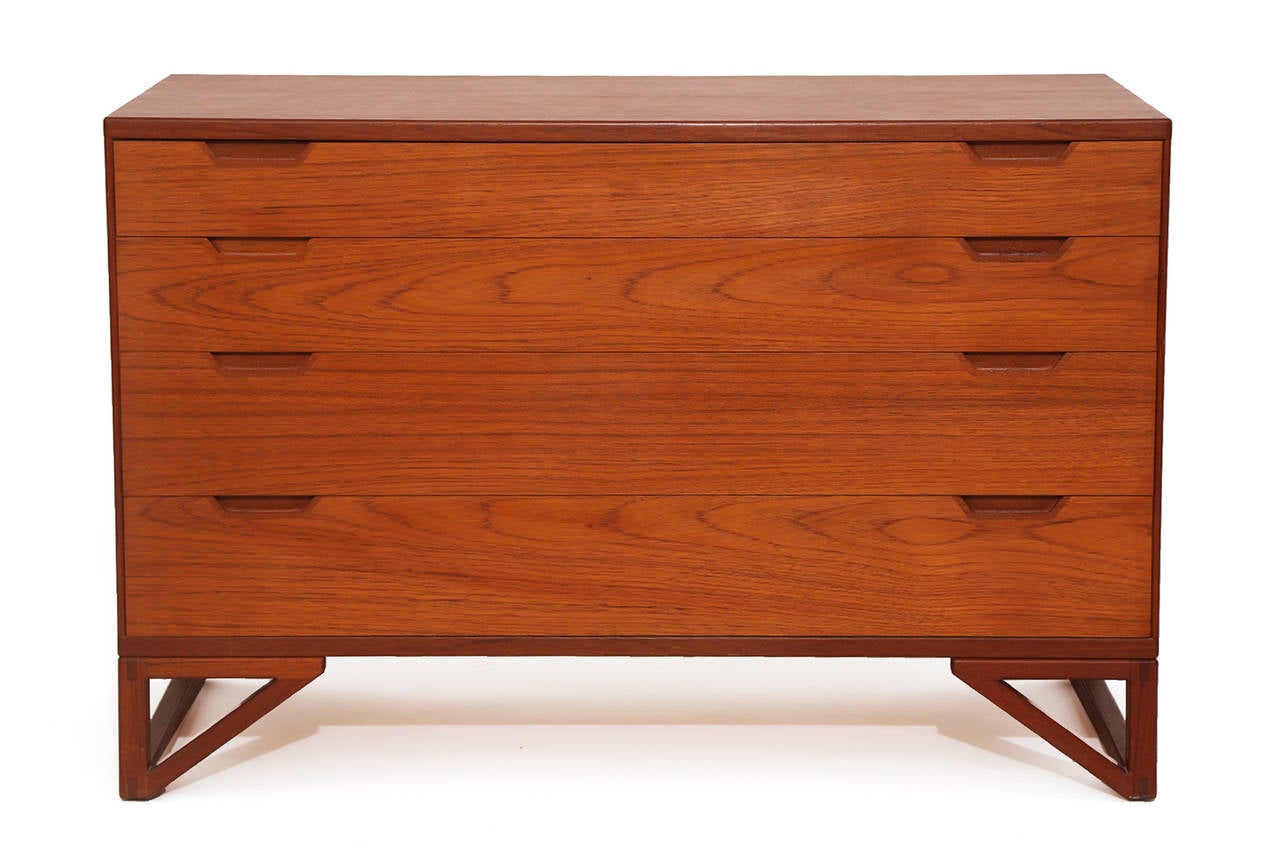 Pair of four-drawer teak chests by Illums Bolighus, circa early 1960s. These all original examples have solid teak architectural bases, inset teak drawer pulls and beautifully grained teak cases. Price listed is for the pair.