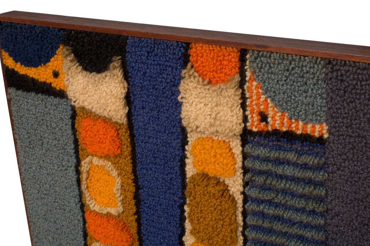 Bill Hinz hand hooked wall hanging circa early 1960's. This lovely and rare example has vibrant hues of blues oranges and yellows and is housed in its original walnut frame.