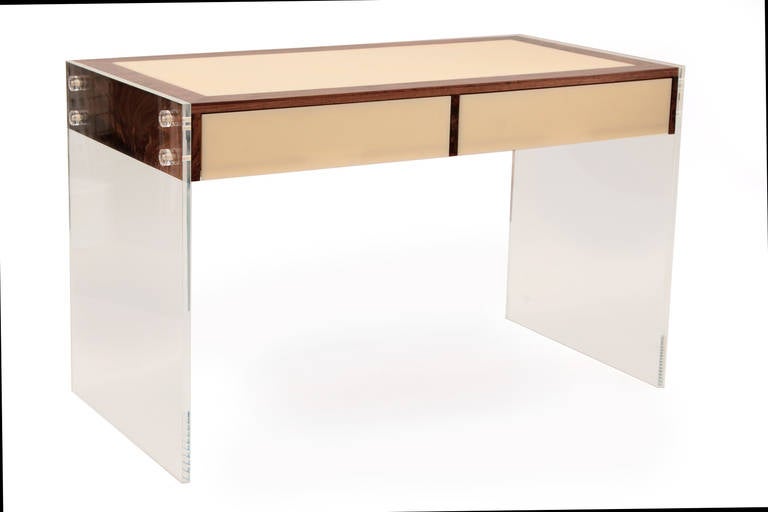 Stunning walnut Lucite and acrylic floating desk or console table, circa mid-1960s. This architectural example has solid clear Lucite sides and cream acrylic drawer fronts and top that are wrapped in figural grained walnut. Measurement to the