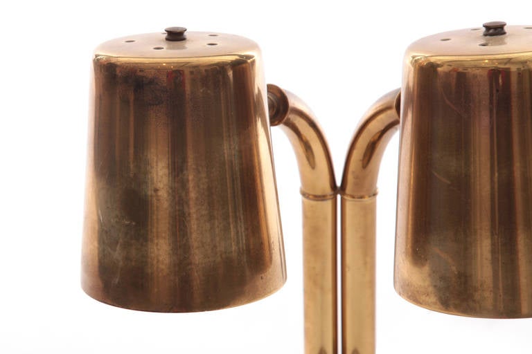 Patinated brass adjustable table lamp circa late 1950s. This stout example has two heads that can be flared out or inand has brass that has aged beautifully.