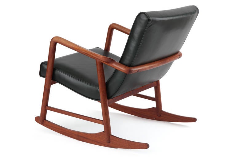 Sculptural solid teak and leather rocking chair from Denmark circa late 1950's. This fabulous example has been newly upholstered in a patinated British racing green leather and has phenomenal flared arm rests.

Seat Height: 18