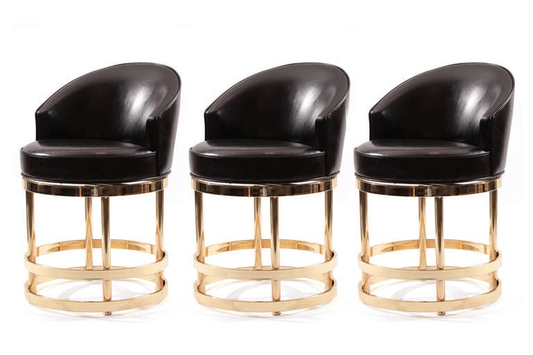 Three leather and mirror polished brass swivel counter height stools circa mid 1970's. These examples have been newly upholstered in a high sheen supple black leather. Price listed is for the set of three.