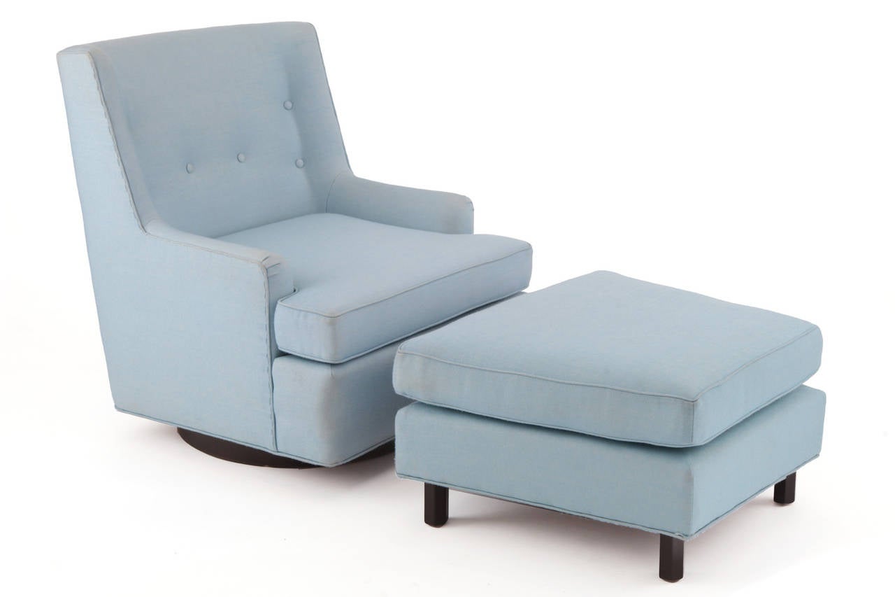 Fabulous Edward Wormley for Dunbar lounge chair and ottoman, circa late 1950s. This example has its original powder blue upholstery. The seat's of the chair and ottoman have been refoamed. The base of the chair is a circular walnut plinth that