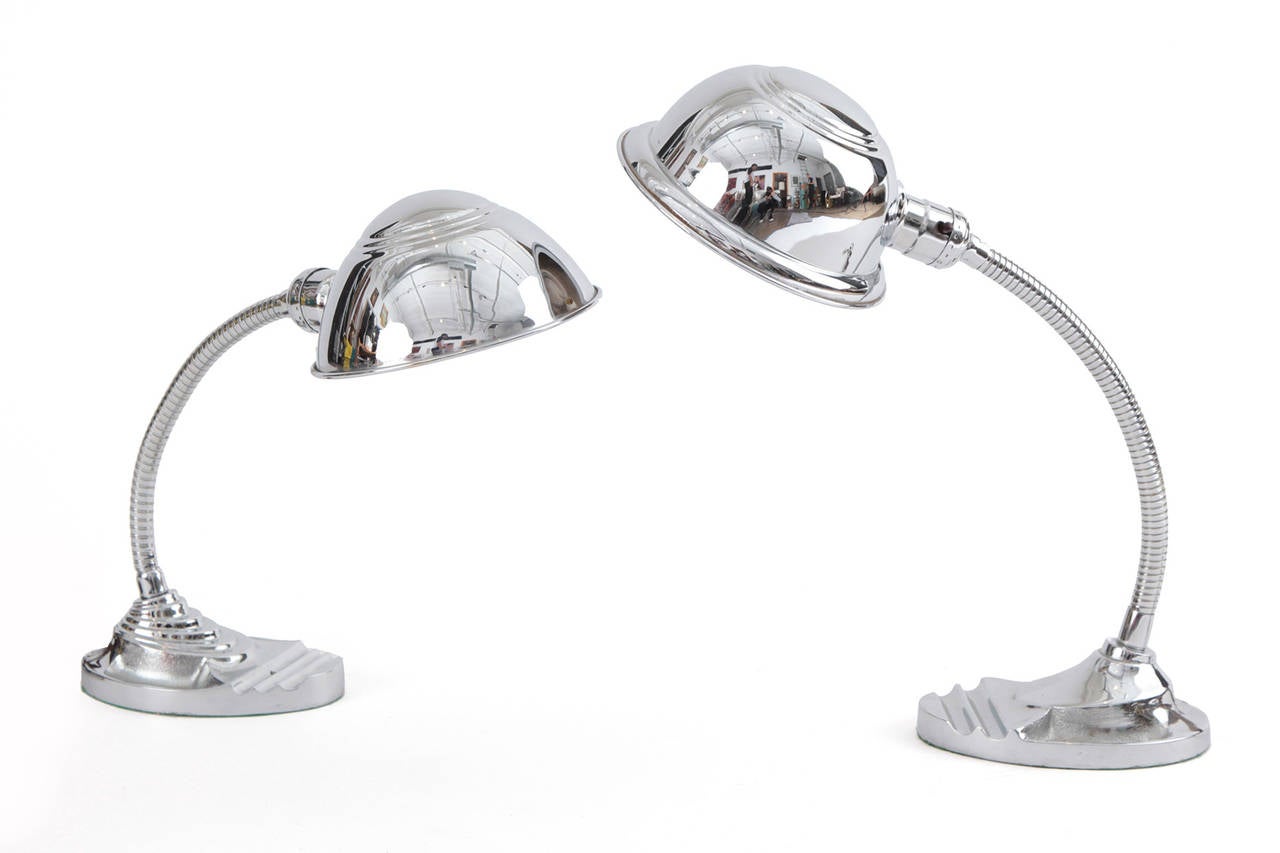 Stunning pair of mirror polished chrome table lamps circa late 1940s. These lovely examples have stepped steel bases articulating domes and bodies and are in excellent condition. They have very slight variations with the shades and bases. Price