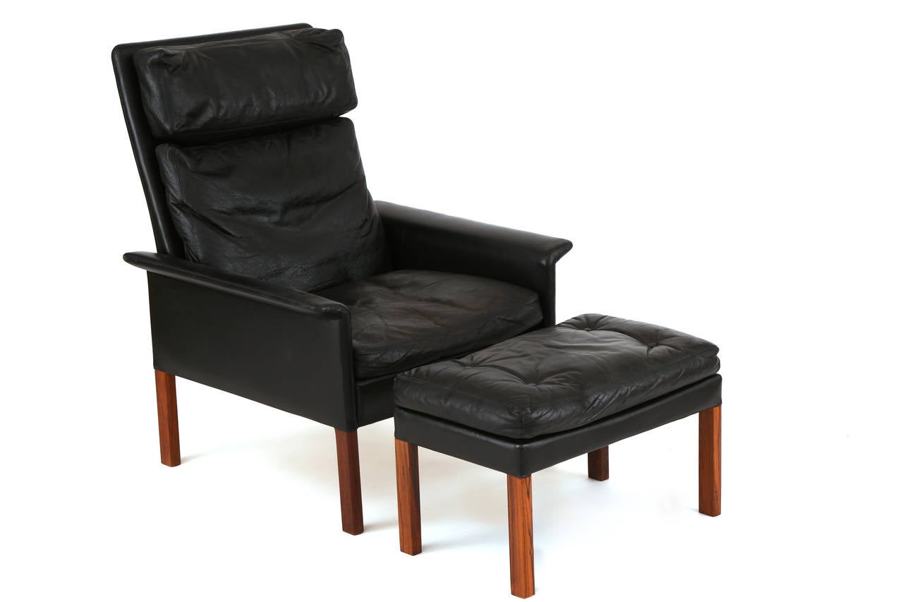 All original Hans Olsen lounge chair and ottoman, circa early 1960s. This example is down filled, is upholstered in its original supple black upholstery and solid rosewood legs. Price listed is for the chair and ottoman. Ottoman measures: 16