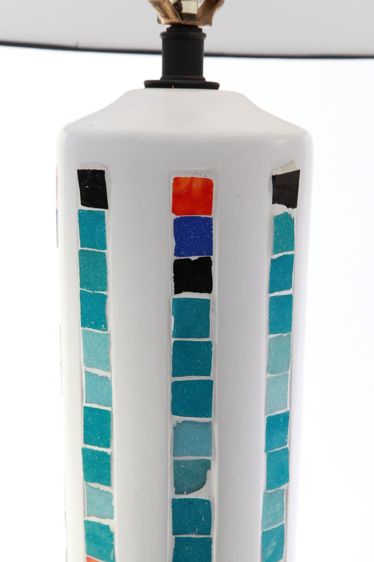 Very large-scale plaster and mosaic tile table lamp from Italy, circa early 1960s. This example has inlaid mosaic tiles ranging from turquoise to black to orange inset on a white plaster body with black base. The shade diameter is 17