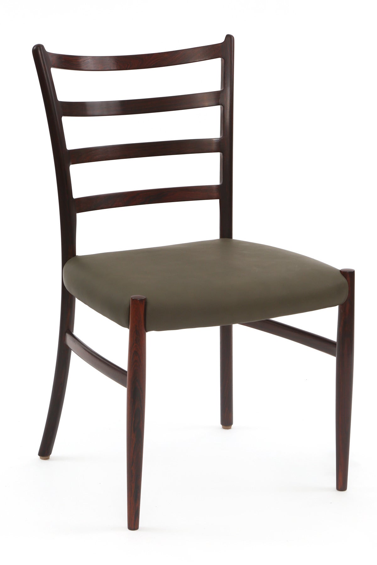 12 solid rosewood and leather dining chairs from Denmark, circa 1960. These examples are solid Brazilian rosewood with subtly curved slat backs. They have been newly upholstered in a stunning sage leather and have been impeccably finished. Price