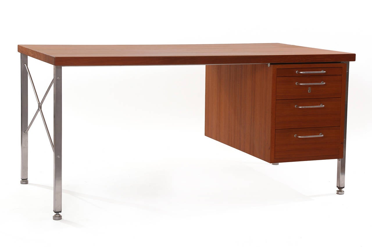 Hans Wegner teak and steel executive desk, circa early 1960s. This all original example has four drawers, curved steel pulls, X-stretchers and beautifully grained top. Space underneath the desk for chair measures: 39