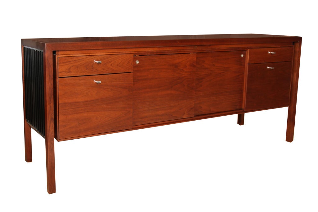 Stunning walnut credenza by Lehigh Leopold circa early 1970's. This example has 4 drawers (2 file drawers) and two sliding doors with adjustable interior shelves. The sides of the credenza are ebonized slats of walnut framed in chrome. Please see