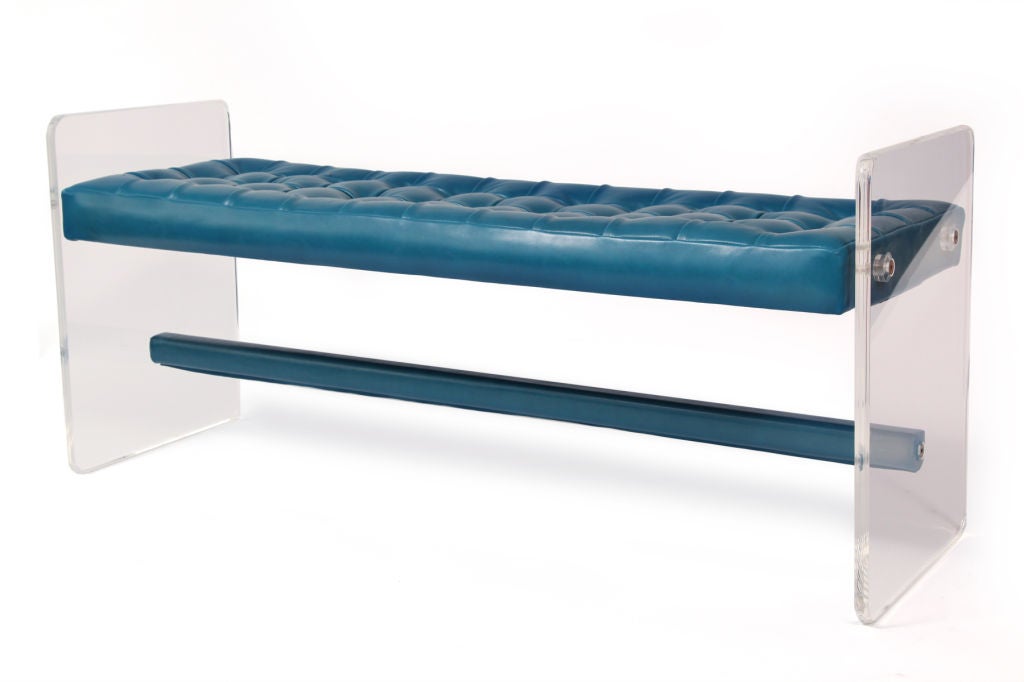 Glamorous lucite and leather bench circa early 1970's. This example is done in a cerulean blue leather that has been tufted without buttons. The stretcher is wrapped and hand sewn in the same leather. The sides of the bench are solid lucite.